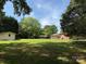 Expansive backyard featuring a well-kept lawn with mature trees and views of the home at 370 Sherrill Farm Rd, Lincolnton, NC 28092