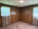 A bright bedroom features carpeted floors and classic wood paneling at 370 Sherrill Farm Rd, Lincolnton, NC 28092