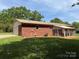 A single-story brick home features an enclosed porch, attached garage, and lush green lawn at 370 Sherrill Farm Rd, Lincolnton, NC 28092