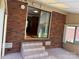 Covered patio with brick accents, tile flooring, and steps leading down to the yard at 370 Sherrill Farm Rd, Lincolnton, NC 28092