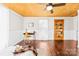 Bedroom with exposed ceiling features hardwood floors, bright white walls, and a charming built-in shelving unit at 406 S Gaston St, Dallas, NC 28034