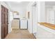 Well-lit laundry room is equipped with a washer, dryer, shelving, and access to a backyard entry door at 406 S Gaston St, Dallas, NC 28034