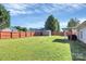 Spacious backyard featuring a large grassy area, wooden fence, and storage shed at 4606 Falcon Chase Sw Dr, Concord, NC 28027