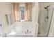 Bright bathroom with a soaking tub, glass shower, and natural light from a window at 4606 Falcon Chase Sw Dr, Concord, NC 28027
