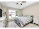 Bright bedroom featuring a large window, tray ceiling, modern furniture, and hardwood floors at 4606 Falcon Chase Sw Dr, Concord, NC 28027