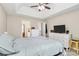 View of a primary bedroom with hardwood floors, ceiling fan, and large TV atop the dresser at 4606 Falcon Chase Sw Dr, Concord, NC 28027