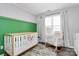 Calming Bedroom featuring a crib, rocking chair, modern decor, and soft natural lighting at 4606 Falcon Chase Sw Dr, Concord, NC 28027