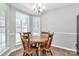 Cozy dining area features a round wood table, chairs, and natural light from three windows at 4606 Falcon Chase Sw Dr, Concord, NC 28027