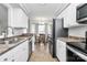 Eat-in kitchen featuring tiled floor, white cabinets, stainless steel appliances, and eat-in dining area at 4606 Falcon Chase Sw Dr, Concord, NC 28027