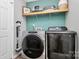 Well-equipped laundry room with modern stainless steel washer and dryer and shelving for storage at 4606 Falcon Chase Sw Dr, Concord, NC 28027