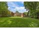 Expansive backyard with lush green grass, mature trees, and a charming patio area for outdoor enjoyment at 4611 Cringle Ct, Charlotte, NC 28226