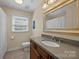 Bathroom features a large framed mirror, neutral paint, tile flooring, and a window letting in natural light at 4611 Cringle Ct, Charlotte, NC 28226