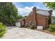 Rear exterior of a brick house with a generator, and driveway leading to garage at 4611 Cringle Ct, Charlotte, NC 28226
