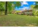 Spacious backyard featuring a well-maintained lawn, mature trees, and a cozy outdoor patio area for entertaining at 4901 White Oak Rd, Charlotte, NC 28210