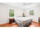 Well-lit bedroom featuring hardwood floors, a ceiling fan and two bright windows at 4901 White Oak Rd, Charlotte, NC 28210