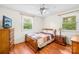 Cozy bedroom featuring hardwood floors, a ceiling fan and two bright windows at 4901 White Oak Rd, Charlotte, NC 28210
