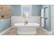 Relaxing bathroom featuring a standalone tub, wainscoting, and lots of natural light at 615 Welker St, Charlotte, NC 28204