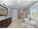 Large bathroom with tiled shower, granite vanity with dark cabinets, and an inviting soaking tub at 615 Welker St, Charlotte, NC 28204
