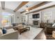 Cozy living room featuring wood beams, stone fireplace, and lots of natural light from french doors and windows at 615 Welker St, Charlotte, NC 28204