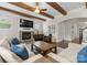 Spacious living room with wood beams, stone fireplace, lots of seating, and an open transition to the stairway at 615 Welker St, Charlotte, NC 28204