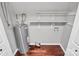 This basement features a hot water heater, storage shelves, dark wood-look flooring, and white walls at 6712 Santa Maria Ln, Charlotte, NC 28227