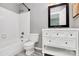 Bright bathroom features a tub with shower, white vanity with drawers, a modern mirror and gray flooring at 6712 Santa Maria Ln, Charlotte, NC 28227