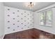 This bedroom features hardwood floors, neutral paint, a bright window, and stylish sunrise-themed decor at 6712 Santa Maria Ln, Charlotte, NC 28227