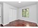 Cozy bedroom features hardwood floors, neutral paint and bright window, and a closet for optimal storage at 6712 Santa Maria Ln, Charlotte, NC 28227