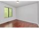 This bedroom features hardwood floors, neutral paint, a bright window, and a closet for storage at 6712 Santa Maria Ln, Charlotte, NC 28227