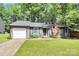 Charming single-story home with gray siding, brick chimney, mature trees, and a well-manicured front lawn at 6712 Santa Maria Ln, Charlotte, NC 28227