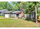 Inviting single-story home featuring well-kept landscaping, a brick chimney, and an American flag at 6712 Santa Maria Ln, Charlotte, NC 28227