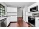The kitchen features white cabinets, stainless steel appliances, and wood floors at 6712 Santa Maria Ln, Charlotte, NC 28227