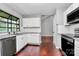Well-lit kitchen features white cabinets, stainless steel appliances, and beautiful wood floors at 6712 Santa Maria Ln, Charlotte, NC 28227