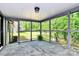 This screened porch features outdoor views, stone flooring, white paint and hanging lights for relaxation at 6712 Santa Maria Ln, Charlotte, NC 28227
