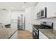 Modern kitchen with stainless steel appliances, granite countertops, and white cabinets at 7004 Everly Commons Ln, Tega Cay, SC 29708