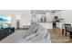 Open-concept living room leading into the kitchen with stainless steel appliances and granite countertops at 7004 Everly Commons Ln, Tega Cay, SC 29708