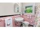 Retro bathroom with pink tile, decorative towels, and window at 7209 Marley Cir, Charlotte, NC 28214