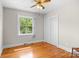 Well-lit empty bedroom featuring hardwood floors, closet space, and a ceiling fan at 7209 Marley Cir, Charlotte, NC 28214