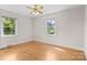 Bright bedroom with hardwood floors, two windows, and ceiling fan at 7209 Marley Cir, Charlotte, NC 28214