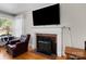 Close-up of living room fireplace with hardwood floors, large windows, and mantel display at 7209 Marley Cir, Charlotte, NC 28214