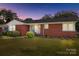 Red brick ranch-style home with a manicured lawn, mature bushes, and a welcoming entrance at 7209 Marley Cir, Charlotte, NC 28214