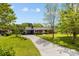 Charming red brick home featuring a covered carport, landscaped yard, and a long private driveway at 7209 Marley Cir, Charlotte, NC 28214