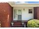 Inviting front porch with decorative plants, brick steps, and a charming security screen door at 7209 Marley Cir, Charlotte, NC 28214