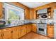 Bright kitchen featuring wooden cabinets, stainless steel appliances, and natural light from the window at 7209 Marley Cir, Charlotte, NC 28214