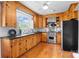 Well-lit kitchen with custom wood cabinetry, stainless steel appliances, and hardwood floors at 7209 Marley Cir, Charlotte, NC 28214