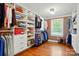 Spacious walk-in closet with custom shelves, drawers, window and hardwood floors at 725 Bradshaw Rd, Mt Ulla, NC 28125