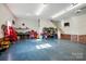 Spacious garage with blue floors, storage shelves, a workbench, and a staircase at 725 Bradshaw Rd, Mt Ulla, NC 28125