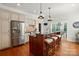 Bright kitchen features wooden floors, a large island with bar seating and stainless steel appliances at 725 Bradshaw Rd, Mt Ulla, NC 28125