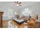 Comfortable living room with a leather sofa, hardwood floors, and ample natural light at 725 Bradshaw Rd, Mt Ulla, NC 28125
