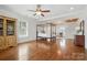 Spacious bedroom with a four-poster bed, hardwood floors, and custom built-in shelving at 725 Bradshaw Rd, Mt Ulla, NC 28125